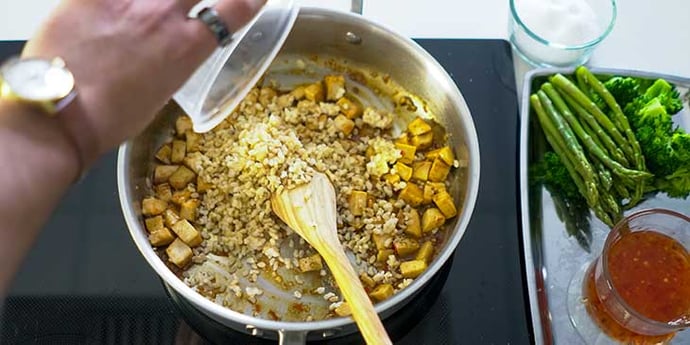 Easy Sweet and Sour Chicken Recipe being cooked in a fry pan and rice being added to pan