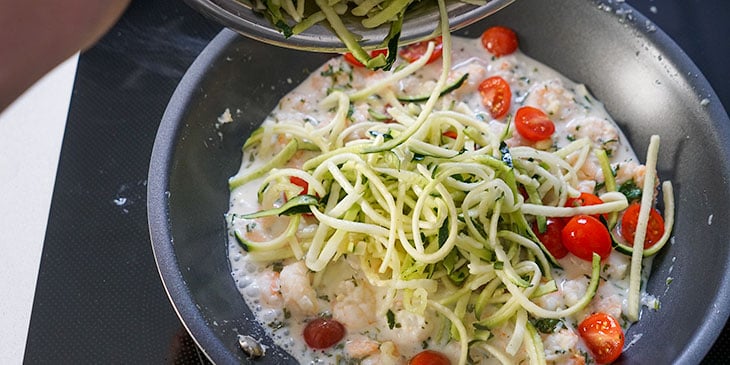 mixing ingredients for garlic shrimp zucchini noodle meal prep recipe