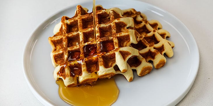 Protein waffles with maple syrup on a white plate